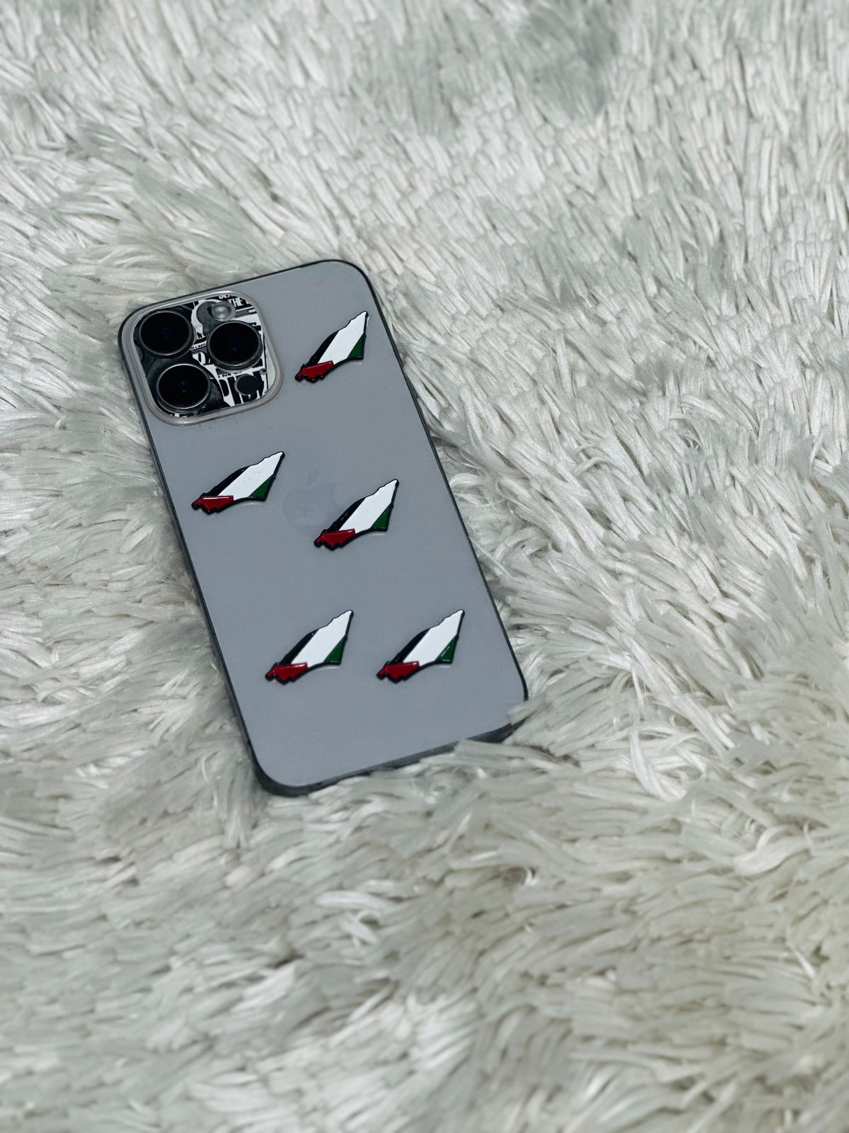 Grey phone case with Palestine flag paper plane charms